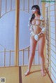 A woman in a white bikini standing in front of a window.