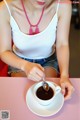 A woman sitting at a table with a cup of coffee.