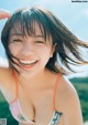 A woman in a bikini smiling at the camera.