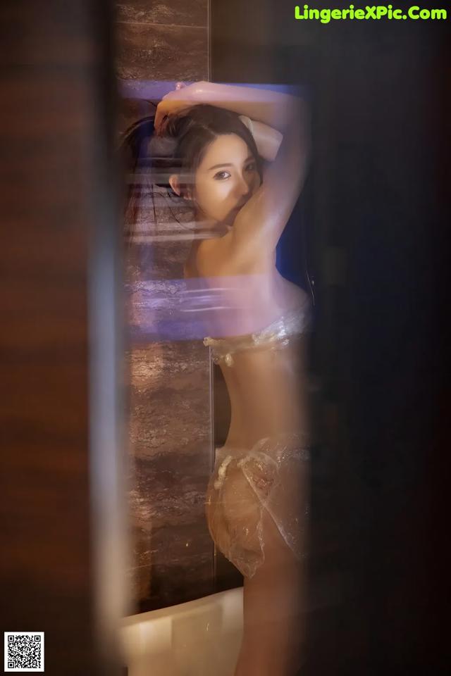 A woman in lingerie standing in front of a mirror.