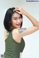 A woman with a tattoo on her arm is posing for a picture.