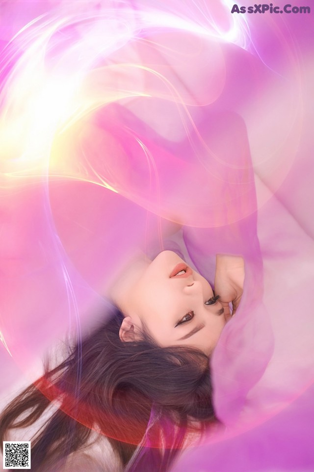 A woman laying on a bed with her eyes closed.