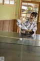 A woman in a kimono playing ping pong.