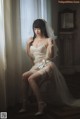 A woman in a wedding dress sitting on a chair.