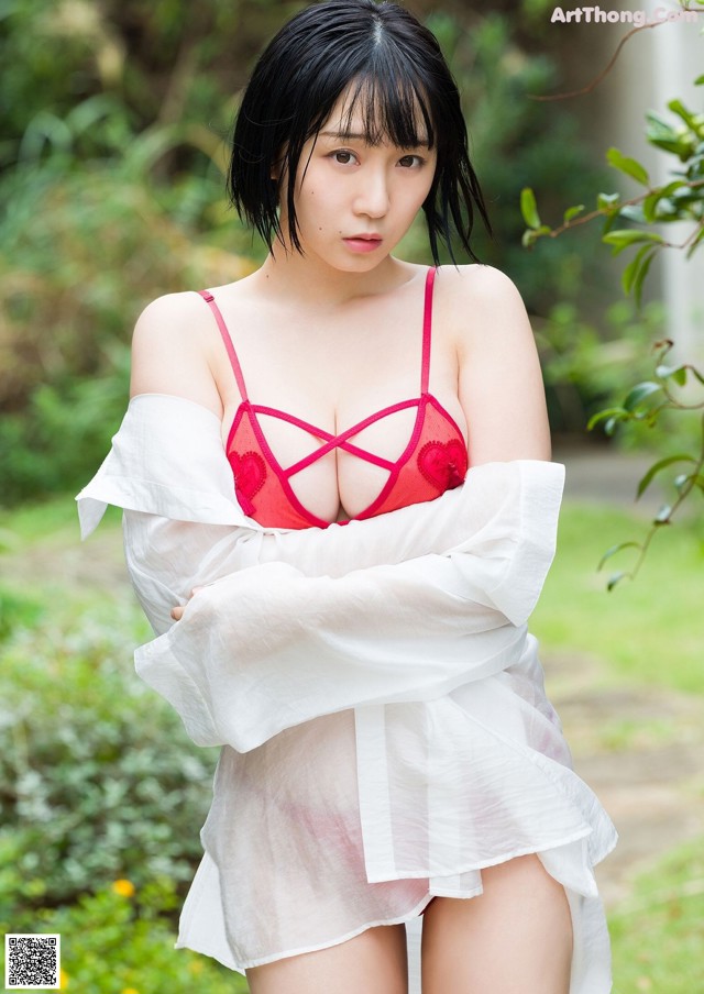 A woman in a red bra and white shirt posing for the camera.