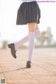 A woman in a school uniform is walking down the street.