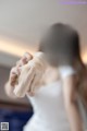 A woman in a white dress holding a piece of cloth.