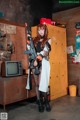 A woman holding a gun standing in front of lockers.